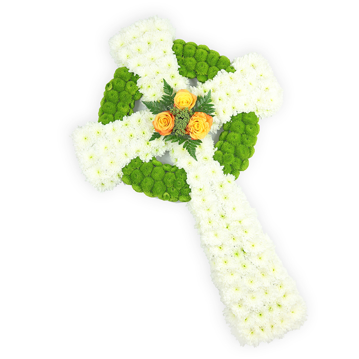 A carefully modelled Celtic cross made of fresh flowers occupies the frame, photographed from a slightly elevated viewpoint against a clean white background that emphasises the arrangement's sculptural form. The cross is predominantly composed of tightly clustered white spray chrysanthemums; their numerous tiny petals create a soft, uniform surface that reads as both tender and reverent. Contrasting sections of bright apple-green button chrysanthemums are thoughtfully set to outline the circular ring where the arms intersect and to alternate within the arms themselves, producing a plush, visually rhythmic pattern that calls to mind traditional Celtic motifs. Anchoring the design, three vibrant orange roses sit precisely at the centre where the arms meet-their warm golden-orange petals offering a poignant focal point against the cooler tones. A few dark green fern fronds or similar foliage nestle around the roses, adding depth and a natural counterpoint to the chrysanthemums' textures. The lighting is gentle, rendering petal edges with soft clarity and casting slight shadows that reveal the cross's three-dimensional relief. As a sympathy tribute, this piece conveys both mourning and celebration of life; its palette even gently echoes the Irish tricolour, making it especially fitting for services honouring Irish roots. From the perspective of a Notting Hill florist serving the local community-Notting Hill Flowers often prepares such memorials for chapels near Kensington Gardens or services around Pembridge Square-this cross communicates meticulous craftsmanship, quiet dignity, and the comforting presence of fresh blooms at a sensitive time.