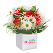 There's a lively, uplifting feeling evoked by this bouquet, perfectly reflecting the welcoming character of Notting Hill. Arranged with an artist's touch inside a crisp, elegant white gift bag, the bouquet pairs warm coral and peach carnations-softly ruffled and velvety to the eye-with classic white daisies whose sparkling green-gold centers bring a burst of freshness. Airy sprays of baby's breath thread delicately between the larger blooms, casting a gentle, floating effect that lightens the composition, reminiscent of spring mornings at Kensington Gardens. Shimmering deep green leaves blanket the base and billow outward, embracing the flowers in a flourish that feels both comforting and refined. Nestled within the bouquet, barely opened buds edged in subtle purple hues hint at unfolding beauty and a touch of intrigue. The scene is beautifully staged on a seamless white background, the bouquet standing proud and inviting, illuminated by soft, natural light that accentuates every curve and color. Designed for moments of celebration or appreciation-a birthday, graduation, new home, or simply to brighten a loved one's day-this arrangement thoughtfully captures the community spirit and eclectic energy that define Notting Hill. Each bloom and leaf speaks of freshness, care, and the joy of artistry honed by the neighbourhood's own florists, ready for same-day delivery throughout the W11 area and beyond.
