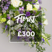 From Notting Hill Flowers, this Florist Choice Special spray stands as a premium, pre-designed option for Notting Hill families seeking a dignified tribute. The arrangement gathers ivory roses with white lisianthus and freesia, while purple blooms enter with authority: deep lisianthus, lavender-eustoma, and delicate spikes of veronica or delphinium reaching upward. Soft lavender statice and bright green viburnum clusters fill the gaps, the ferns and glossy leaves providing a lush, natural frame. The composition sweeps in a generous spray, with a gentle downward cascade that feels both celebratory and serene, set against a pale grey studio background that makes the colours glow. A crisp white overlay at the centre bears Florist Choice Special in a flowing script above CHOICE SPRAY in uppercase, followed by the bold price ?300. This image communicates a premium, bespoke option ideal for sympathy, funeral tributes, or a grand floral gift; Notting Hill locals can arrange same-day delivery across Notting Hill and nearby areas, with the bouquet fresh from Notting Hill Flowers near Portobello Road Market.